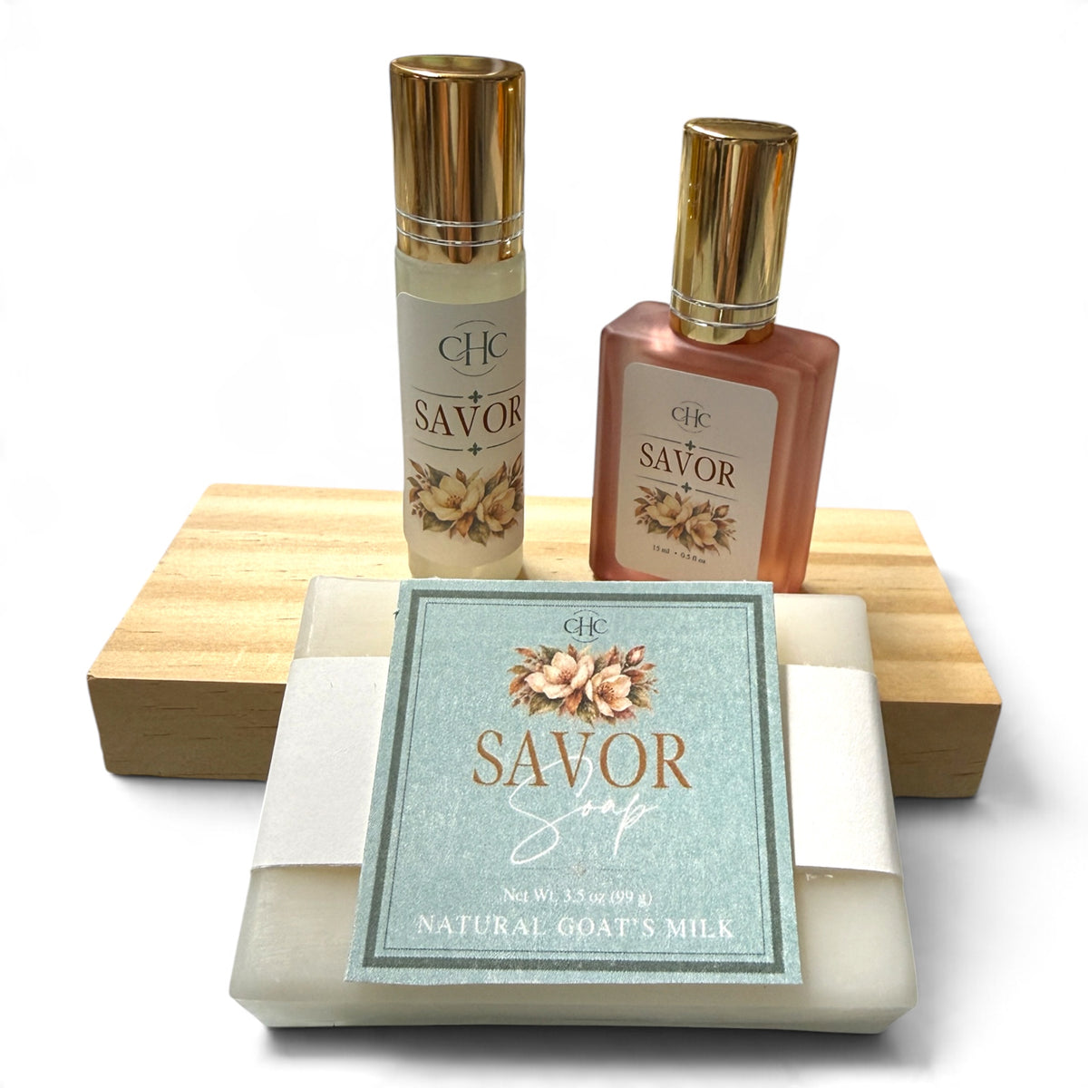 Savor Scent Trio Gift Set in Amber Noir: alcohol-free perfume spray, roll-on perfume and goat milk soap on a wooden soap dish