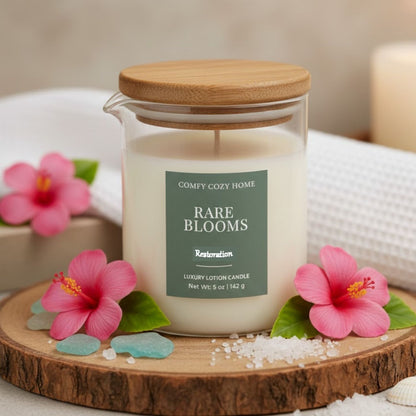 Candle labeled 'Rare Blooms' from 'Comfy Cozy Home' on a wooden coaster with pink flowers.