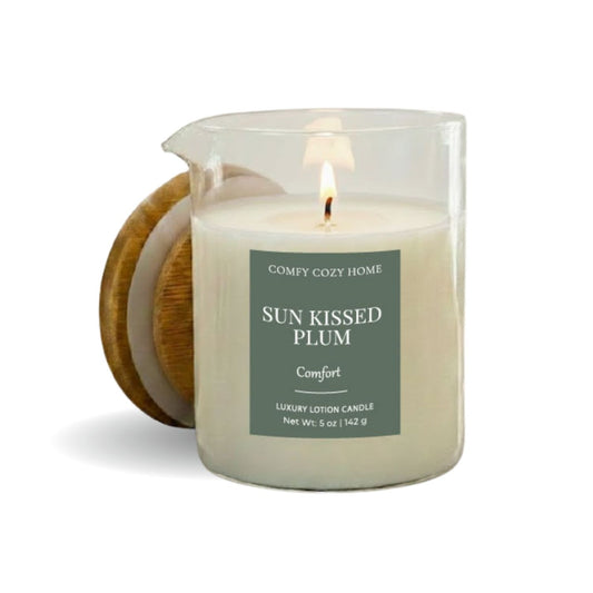 Candle labeled 'Sun Kissed Plum' from 'Comey Cozy Home' with a wooden coaster on a white background